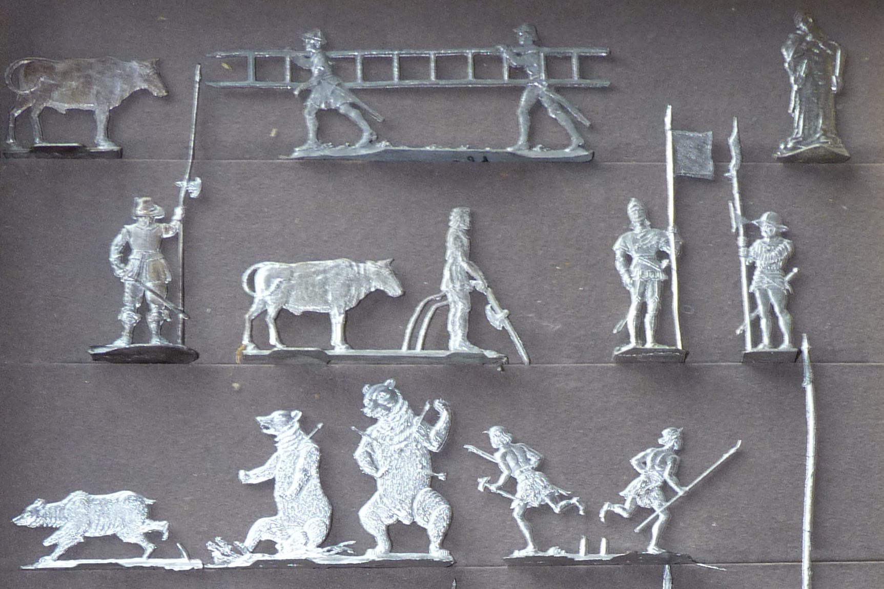 Viele Zinnfiguren, die zum Beispiel Ritter, Bären und einen Bauern mit Rind darstellen.