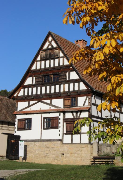 Ein Haus mit viel Fachwerk und einem Baum im Vordergrund