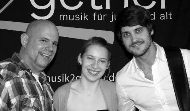 das Musiktrio, zwei Männer und eine Frau in der Mitte freuen sich auf den Auftritt.