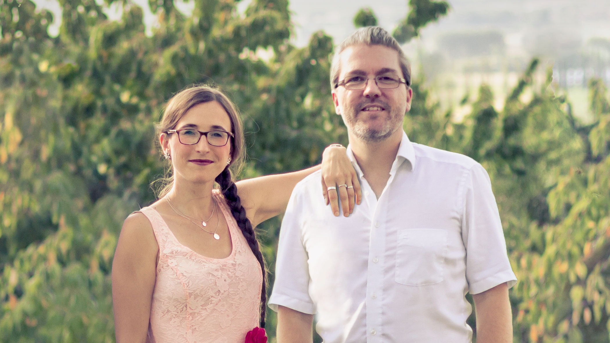 Eine Frau und ein Mann in Sommerkleidung in grüner Landschaft