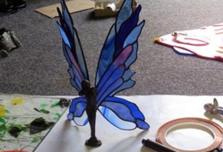 Kleine Figur mit gläsernen Schmetterlingsflügeln