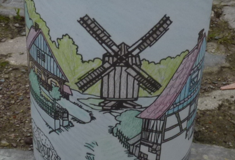 Weiße Papierlaterne mit Aufdruck einer farbigen, historischen Windmühle.